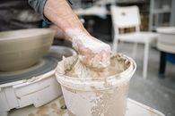 Selective Focus Photo of a Person Grabbing Clay