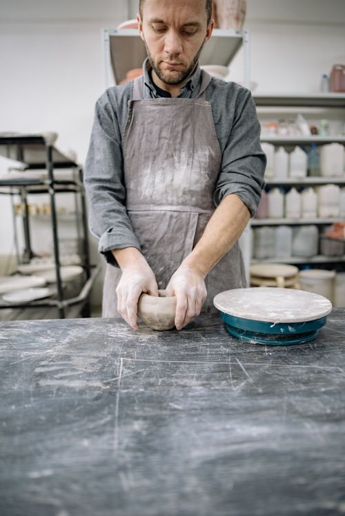 Free A dedicated artisan skillfully molds clay in a pottery studio, showcasing craftsmanship. Stock Photo