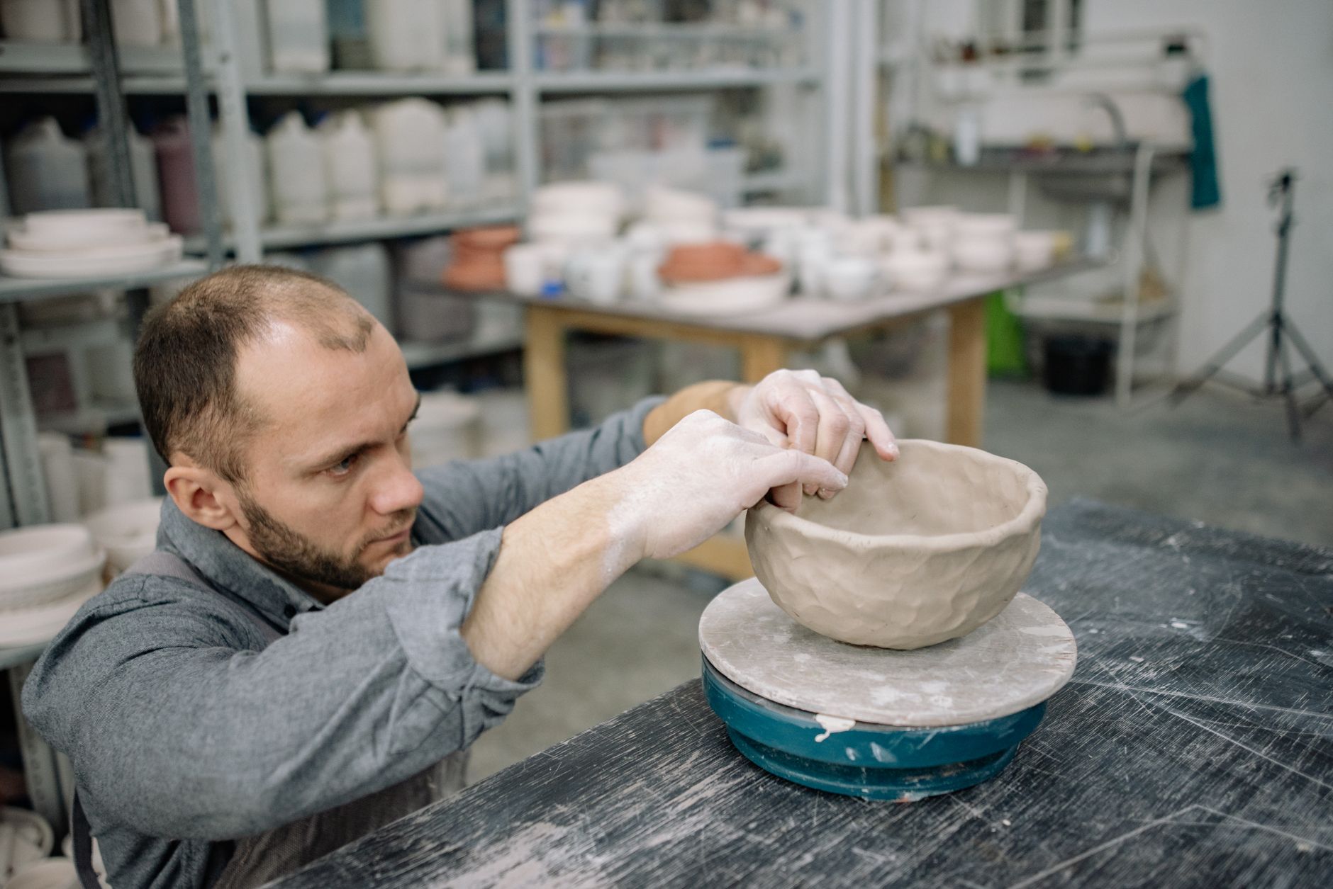 One of our tutors shaping a hand-built bowl at the bench in the studio.
