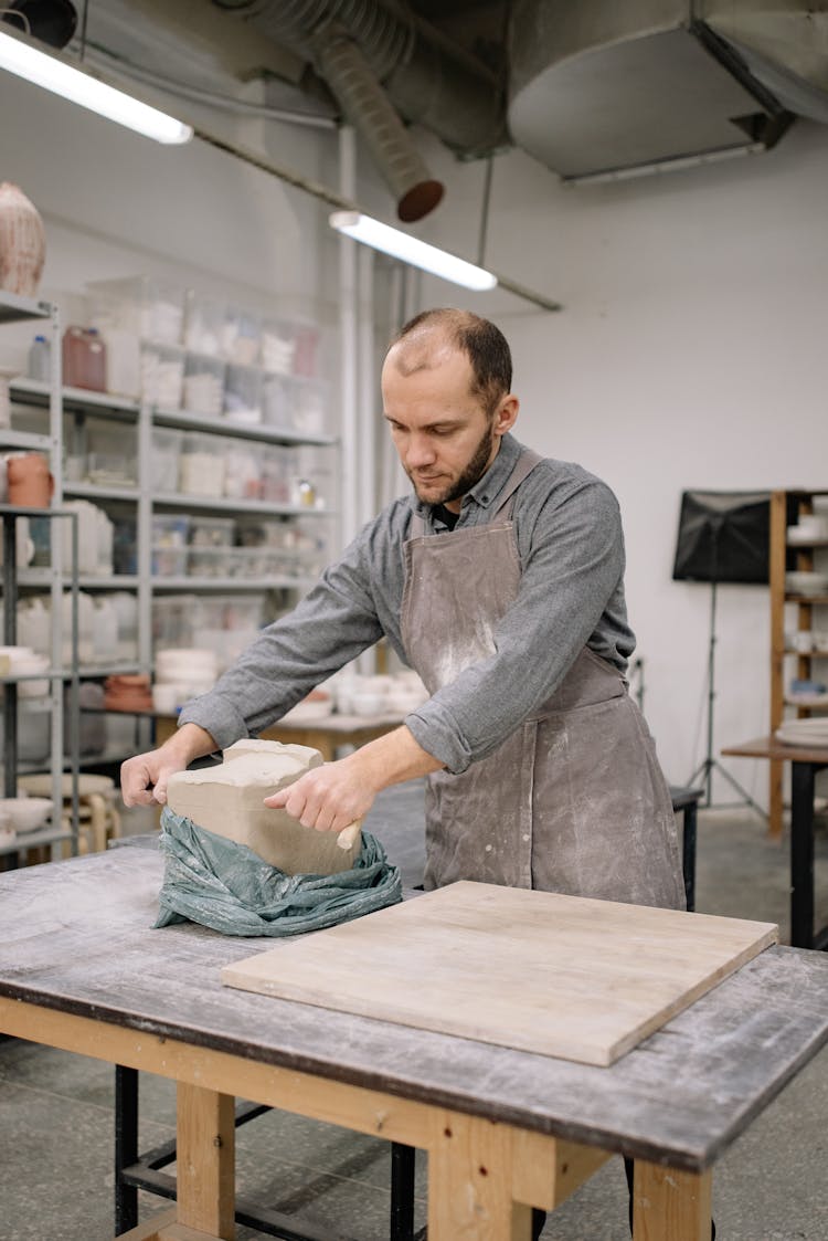 Man Taking Out Block Of Clay