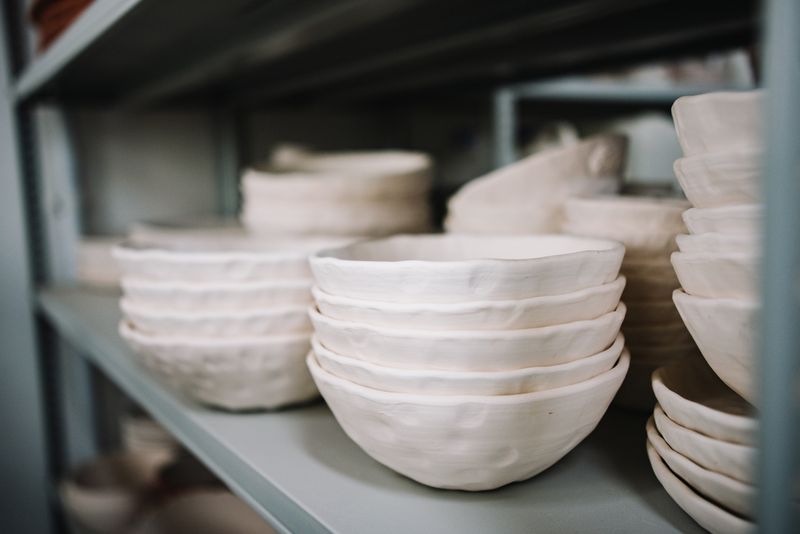 Stacked handmade stoneware bowls resting on a studio shelf.