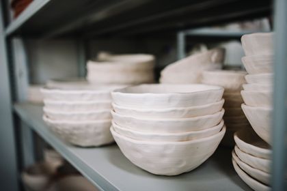 Stacked handmade ceramic bowls on a shelf. Photo by Yan Krukau on Pexels