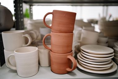 Stacked handmade ceramic mugs and plates — photo by Yan Krukau on Pexels