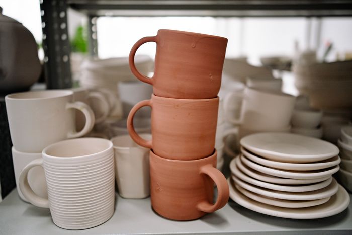 Stacked terracotta and cream mugs on a studio shelf by Yan Krukau on Pexels