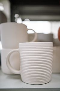Mugs stacked on a kitchen shelf — photo by Yan Krukau on Pexels