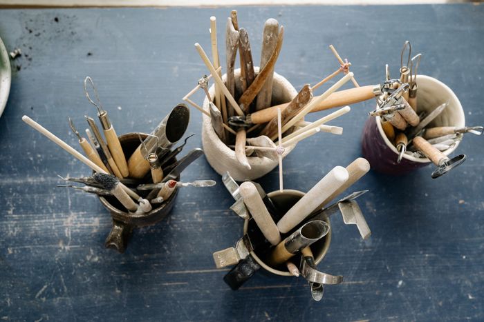 Ceramic sculpting tools standing in mugs on a workshop table — Yan Krukau on Pexels