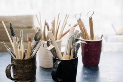 Pens and brushes standing in glazed mugs — photo by Yan Krukau on Pexels