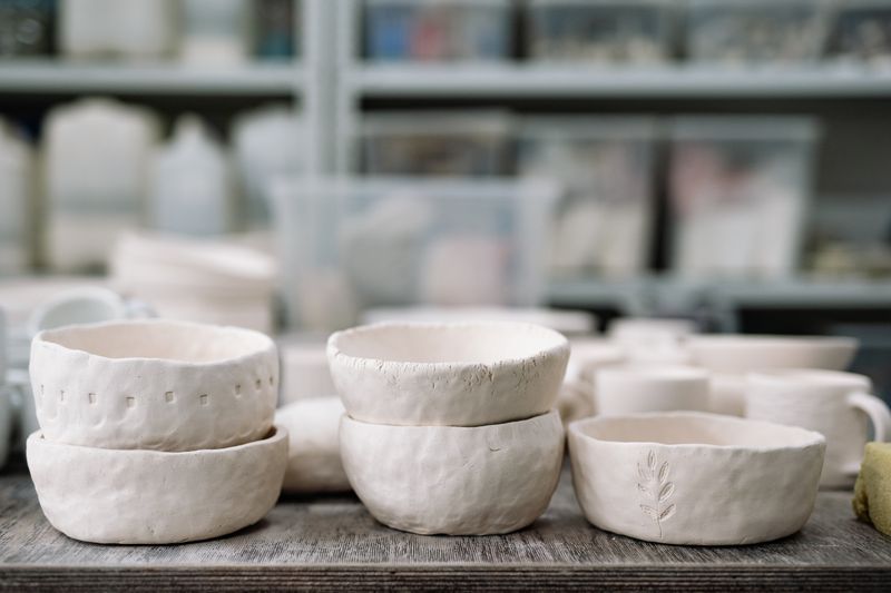 Unglazed ceramic bodies drying on a shelf