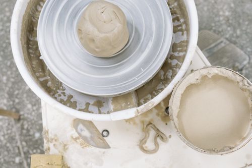 Free Clay ready on a pottery wheel for shaping, ideal for ceramic art enthusiasts. Stock Photo