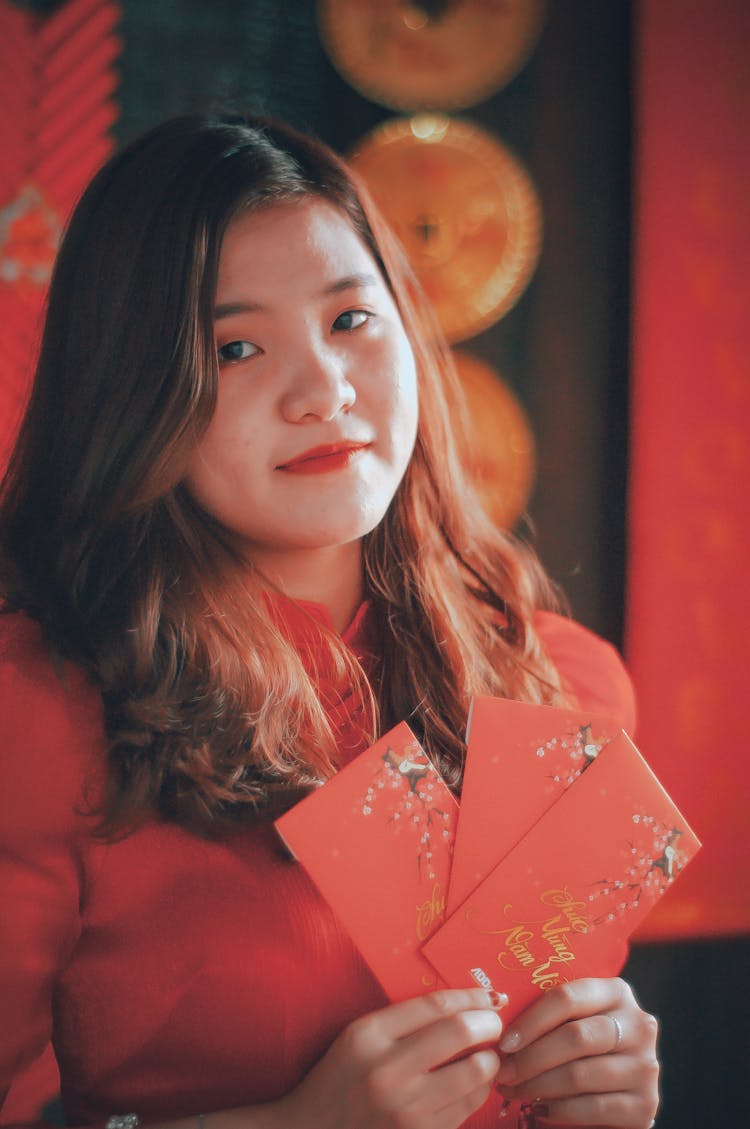 Woman In Red Top Holding Red Packets