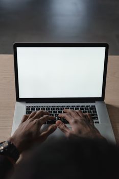 Hands typing on a laptop with a blank screen, perfect for mockup or design use.