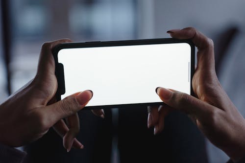 Free A Person Holding Smartphone with Blank Screen Horizontally Stock Photo
