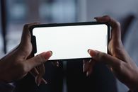 A Person Holding Smartphone with Blank Screen Horizontally