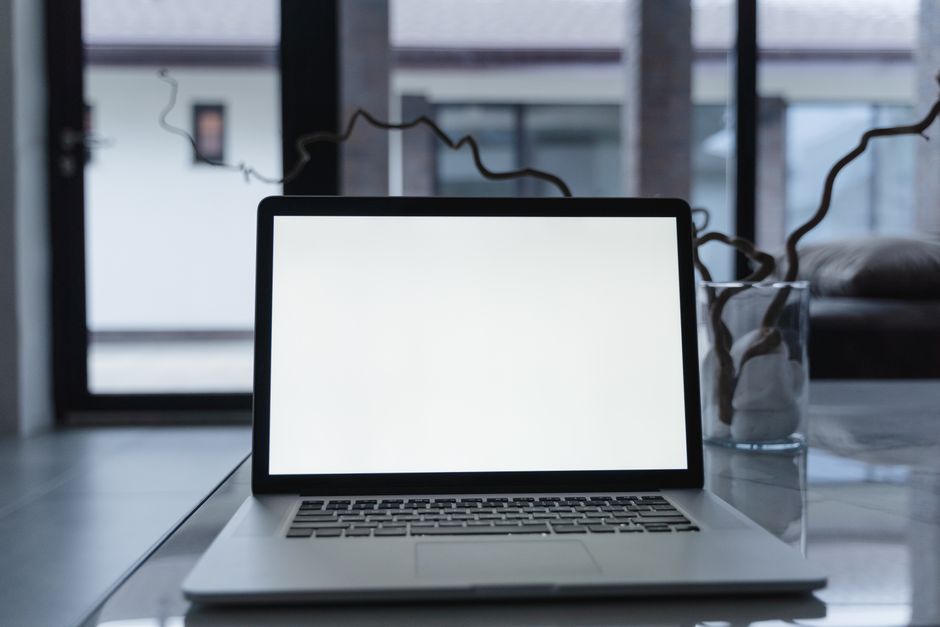 ExpressVPN Lightway vs NordVPN NordLynx: Speed and Security Compared Laptop with blank screen on a reflective table indoors, perfect for mockups and presentations.