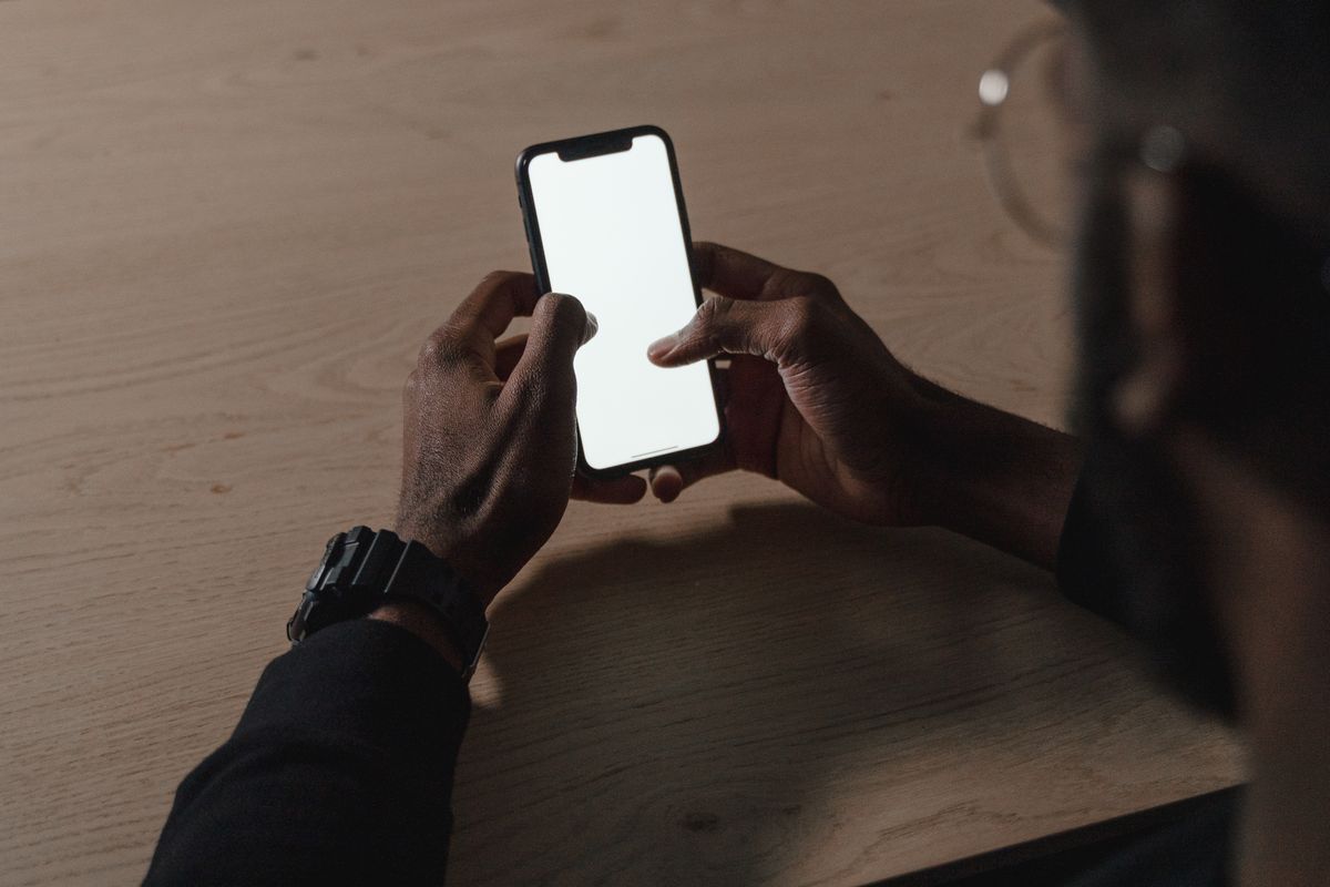 Elde tutulan akıllı telefon ekranında dijital içerik görüntüleniyor