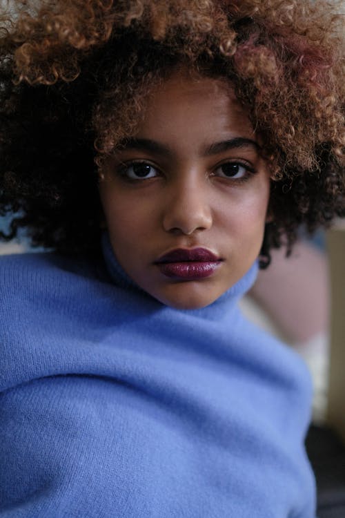 A Pretty Woman with Afro Hair in Blue Top