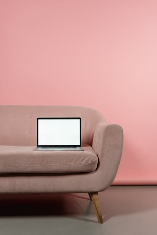 Black Laptop on Top of Pink Sofa