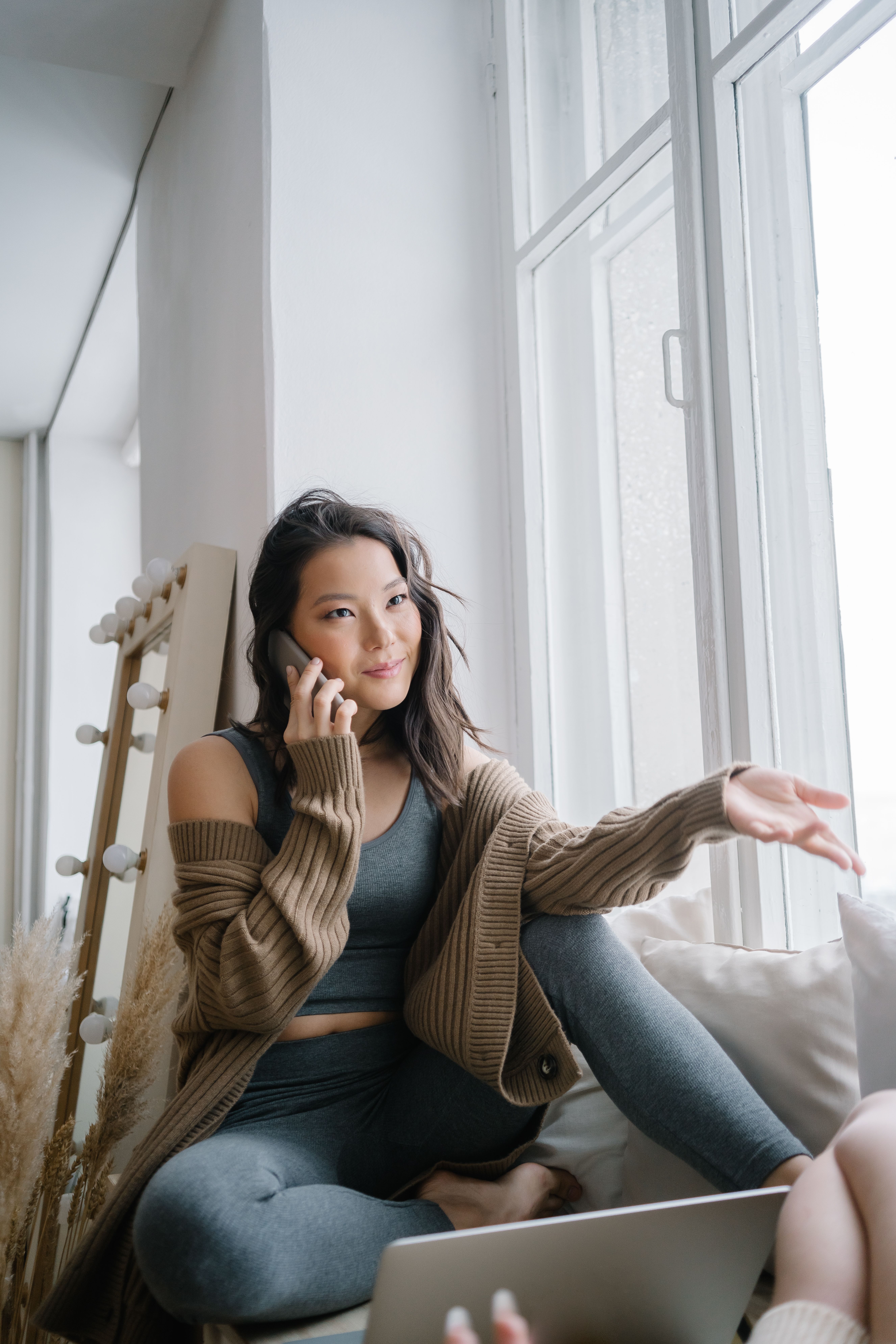 person talking on phone by window at home