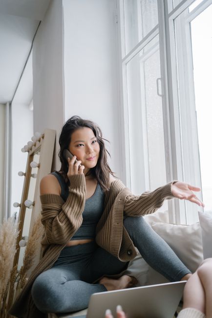 person talking on phone by window at home