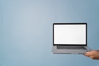 Close-Up Shot of a Person Holding a Laptop