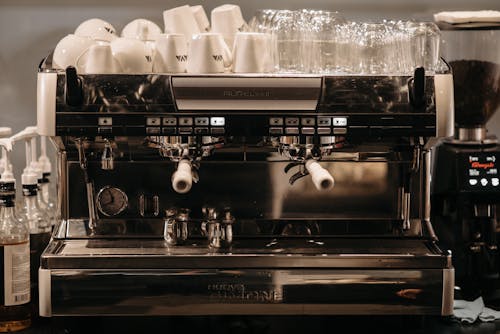 Free Mugs and Glasses on Top of a Coffee Maker Stock Photo