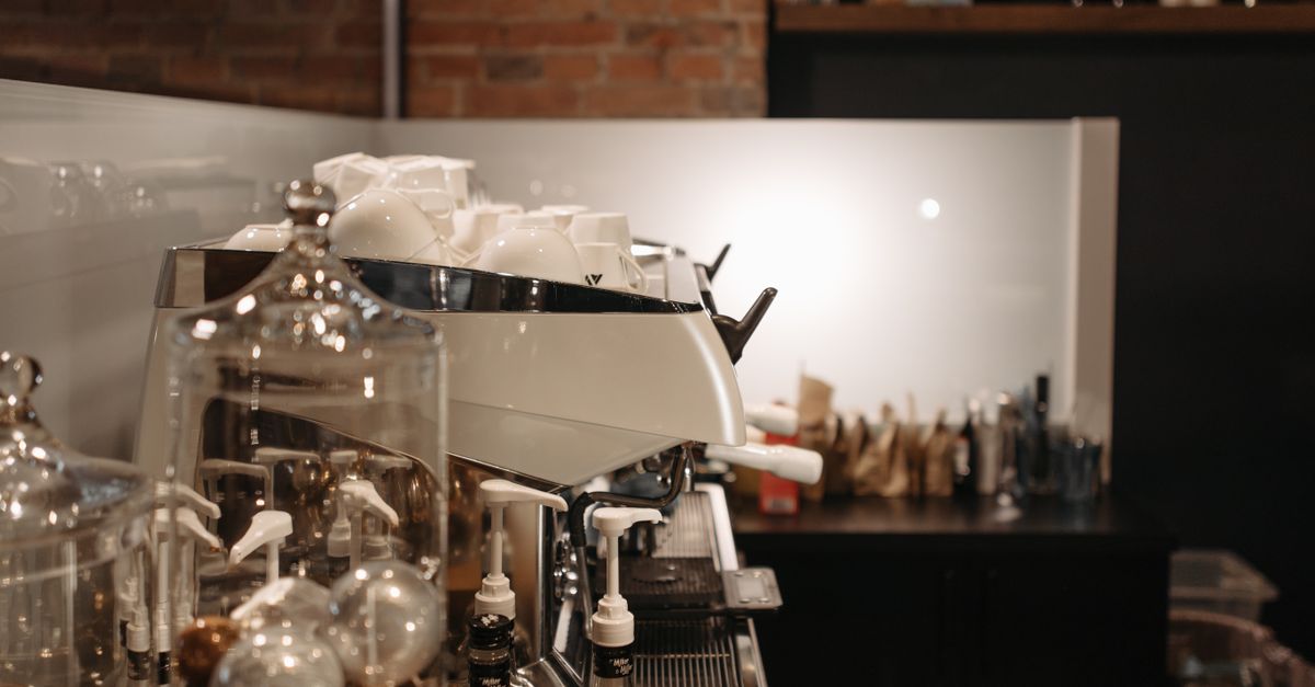 A cozy coffee shop interior featuring a modern espresso machine and various coffee accessories.