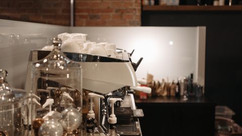 A cozy coffee shop interior featuring a modern espresso machine and various coffee accessories.