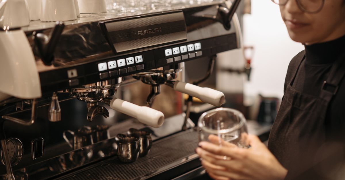 A barista pulling an espresso shot in a cafe