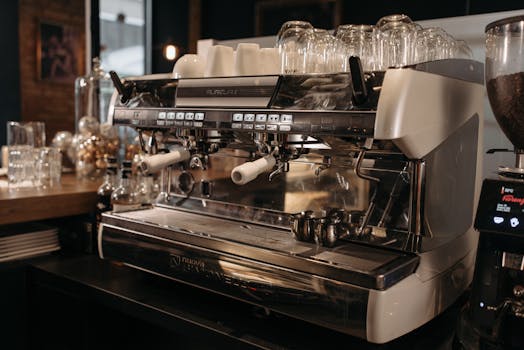 A sleek espresso machine poised for brewing in a warmly lit cafe ambiance.