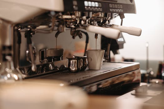Espresso machine brewing fresh coffee in a cafe, focusing on drip into cup.