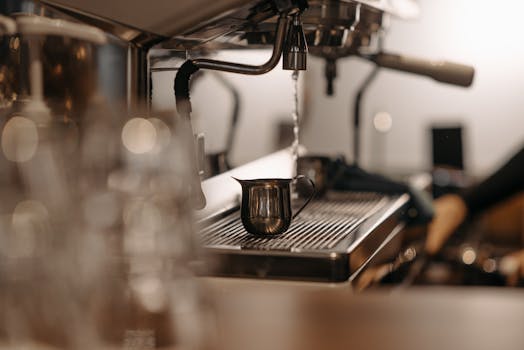 Close-up view of an espresso machine with a metal pitcher, perfect for coffee brewing context.