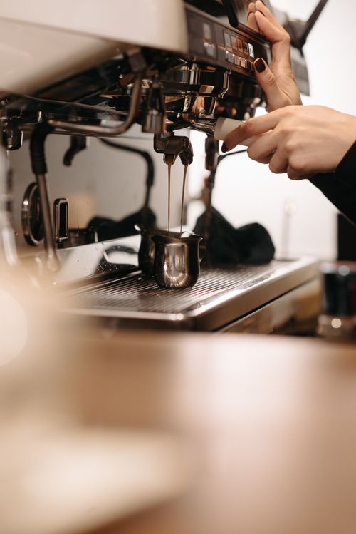 Free A barista preparing espresso with a machine, showcasing hands-on coffee making. Stock Photo