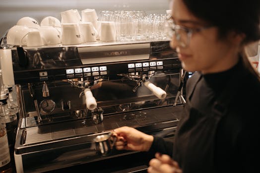 A focused barista brews coffee using a professional espresso machine in a cozy cafe setting.