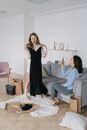 Woman in Black Dress Sitting on Gray Couch