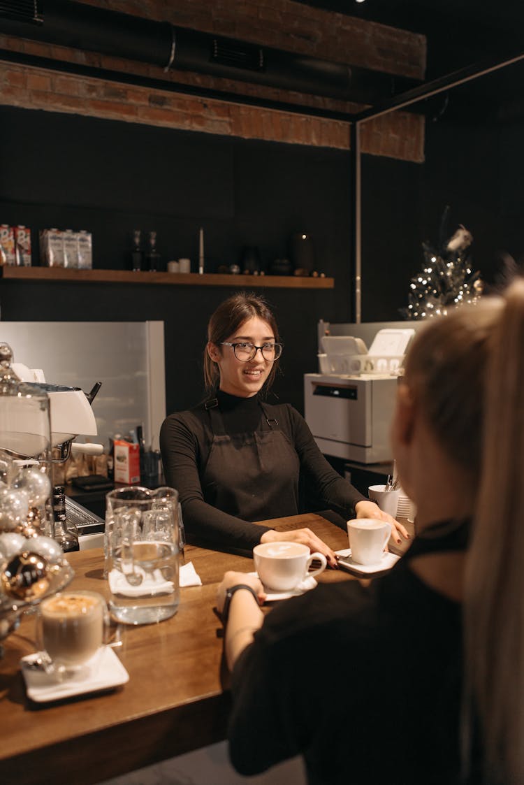 A Barista Serving Cups Of Coffee To A Costumer