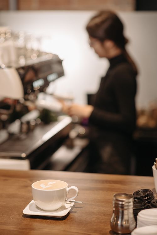 Free A barista preparing coffee with latte art at a modern cafe. Stock Photo