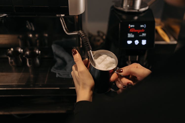 A Person Whipping A Cream Using A Steam Wand