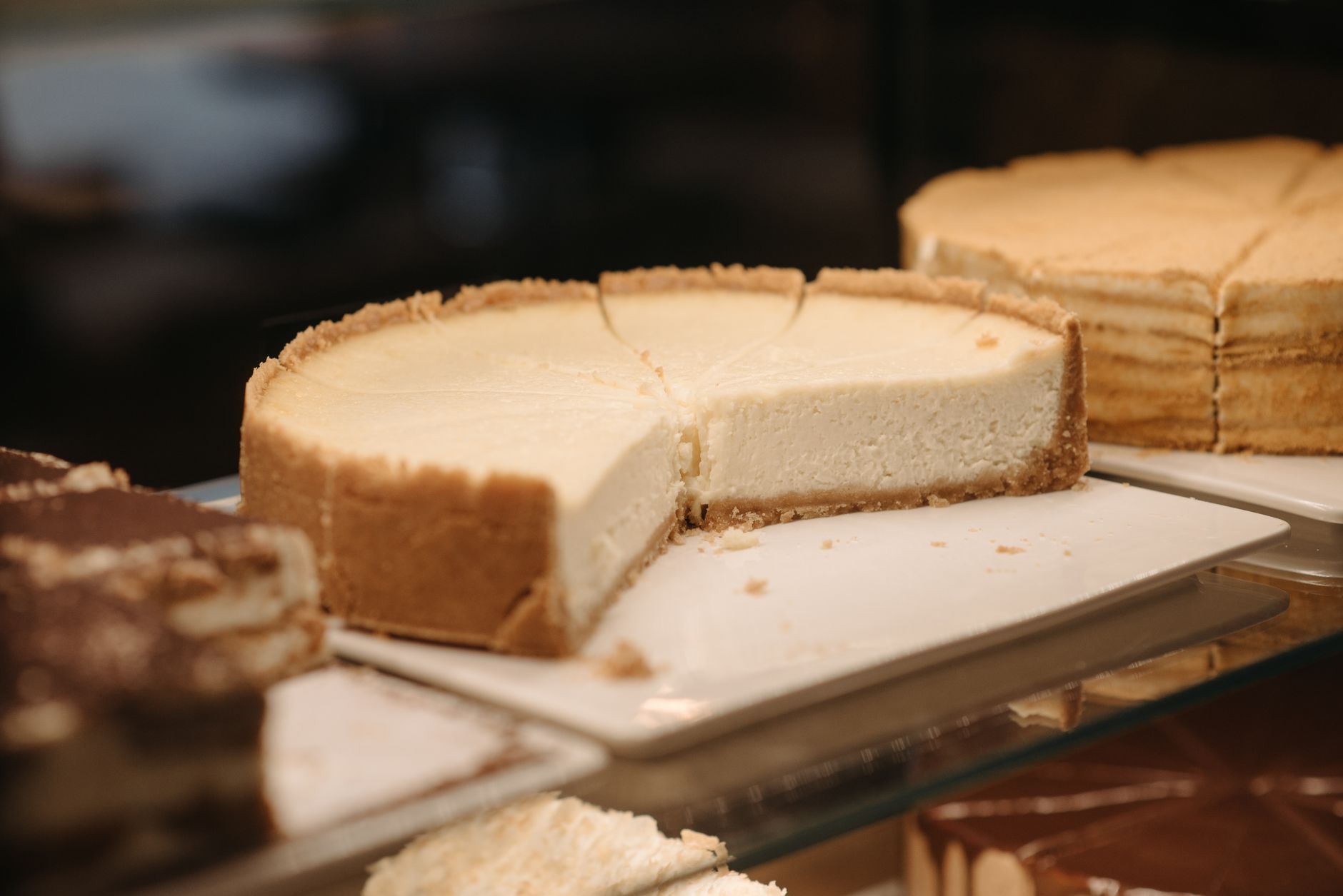 Hand spreading cheesecake filling smoothly into a pan