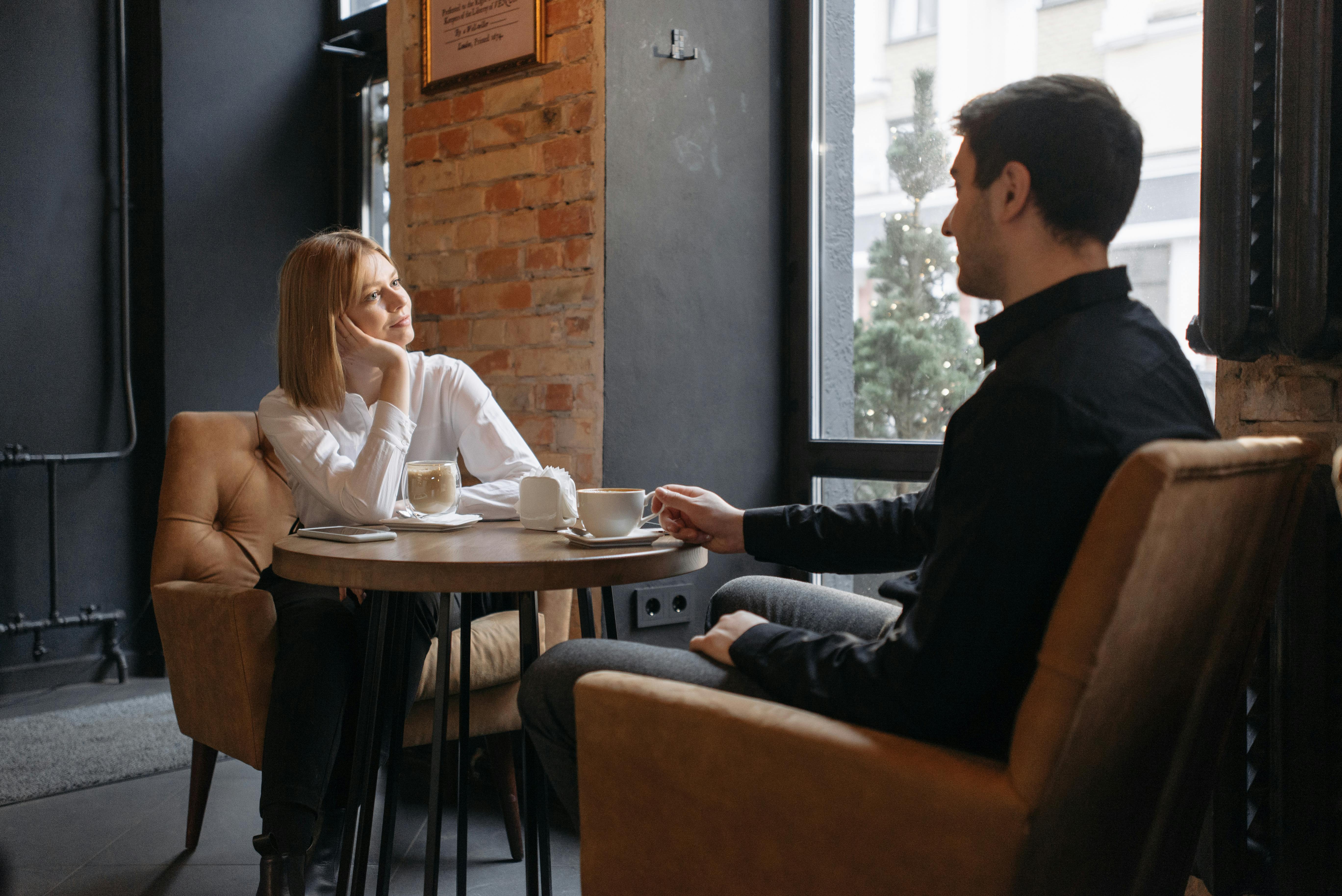 Man and Woman Sitting on Sofa Chair at the Coffee Shop · Free Stock Photo