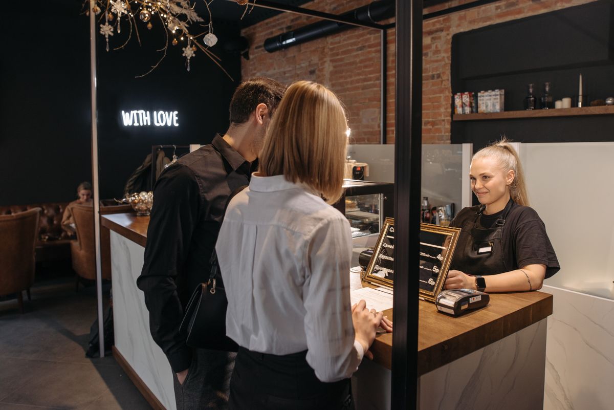 Barista serving a customer at a cafe counter, for illustration