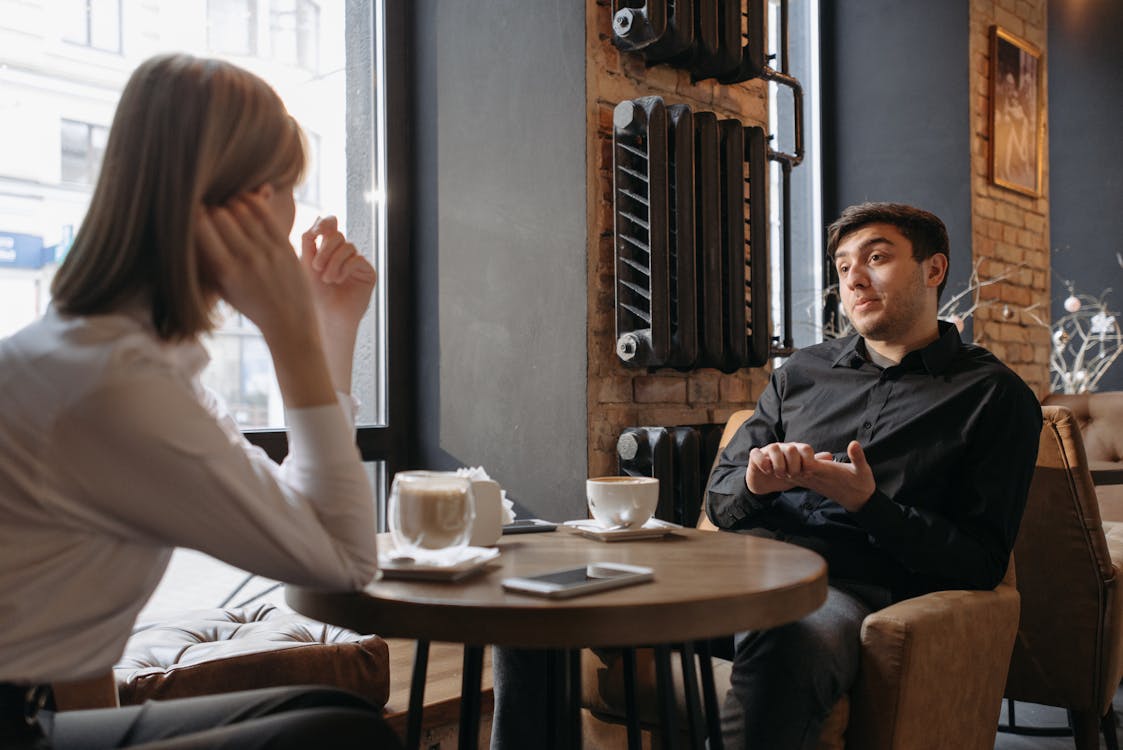 {{https://mixerdates.com/?ch=mixerblog}}Relaxed meeting in a cozy café with two people discussing over coffee