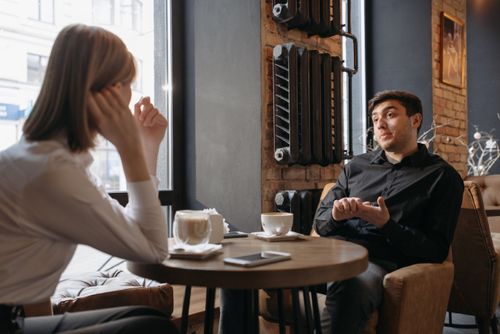 Free Relaxed meeting in a cozy café with two people discussing over coffee. Stock Photo