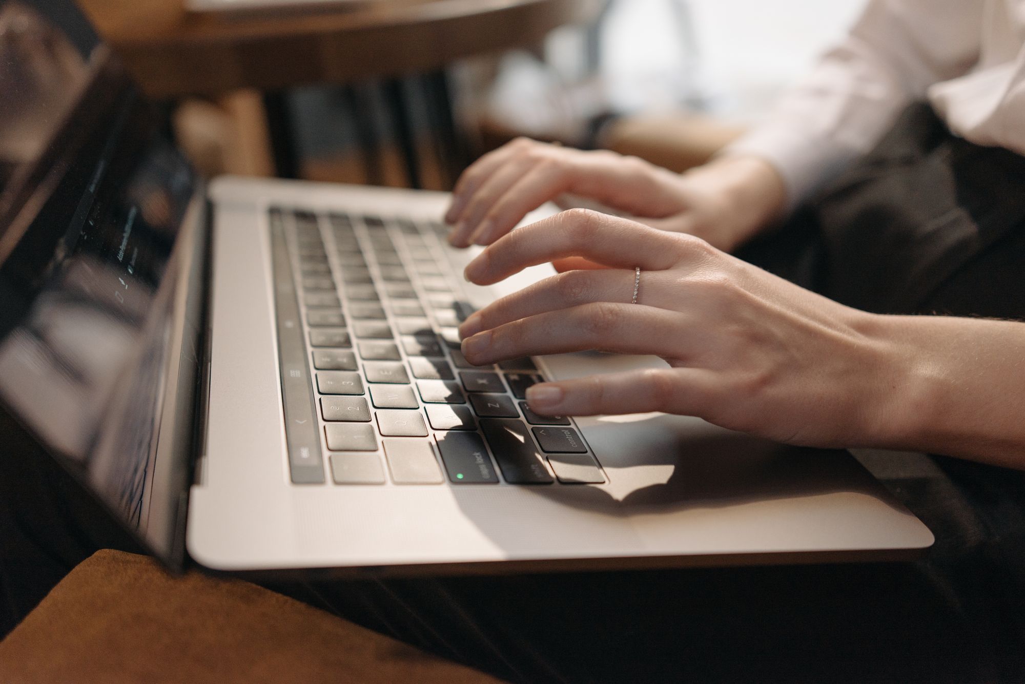 Manos sobre el teclado de una laptop con un navegador abierto en pantalla