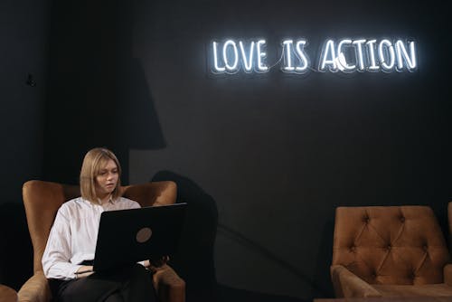 A Woman in White Top Using a Laptop 