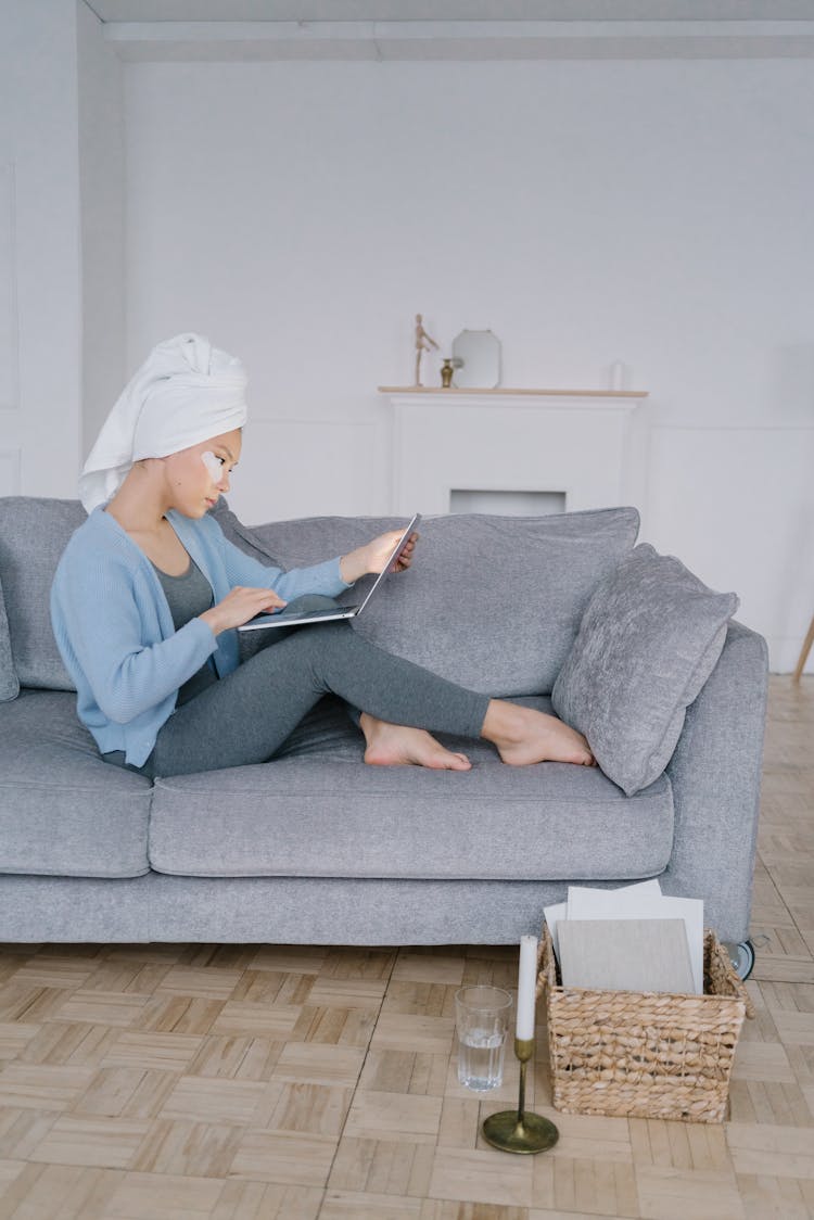 Woman With White Head Towel Sitting On Gray Couch