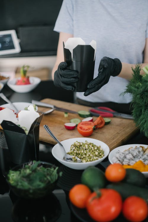 Person with Black Gloves Preparing a Take Out Food