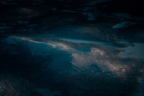 Picturesque aerial view of mountain ridge covered with snow and lush woods in winter evening