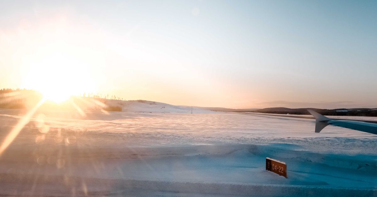 Flight Window Snow Scenery of snowy runway from aircraft window at sundown · Free Stock Photo