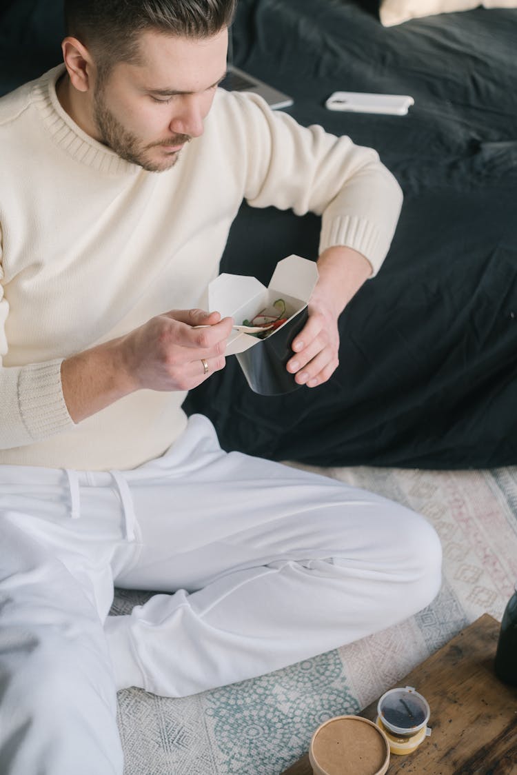 A Man Holding A Take Out Food