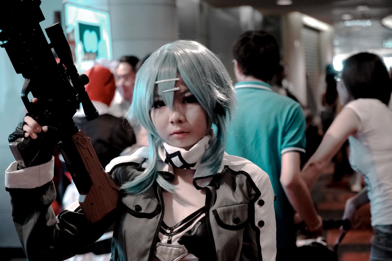 vibrant cosplay participant posing indoors at a bustling convention sc